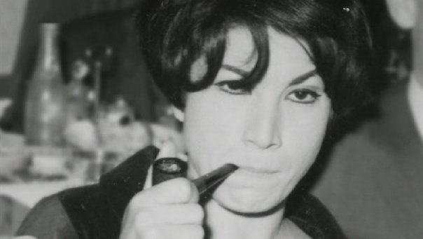 Black and white photograph of Forugh Farrokhzad smoking a pipe.