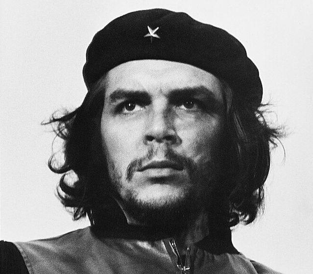 Black and white portrait of Che Guevara wearing a black beret and leather jacket, staring beyond the camera.