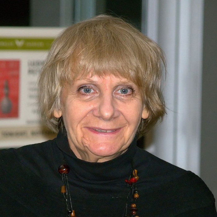 A woman with short blond hair in a black turtleneck. 