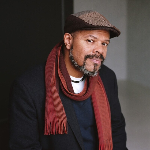 Image of John Keene in a black coat and a red scarf.