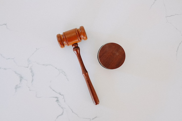 A brown gavel against a white, marble surface.