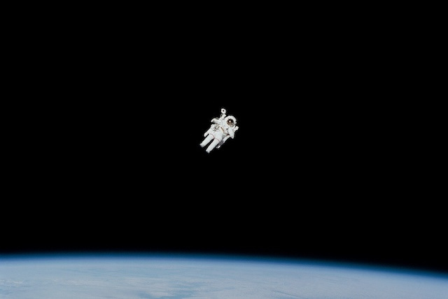 An image of the astronaut floating in space over earth.